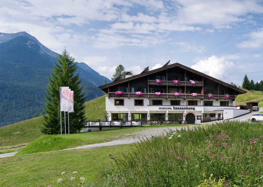 Außenansicht auf die Appartements DER SONNENHANG. mit Fahnen und grüner Wiese.